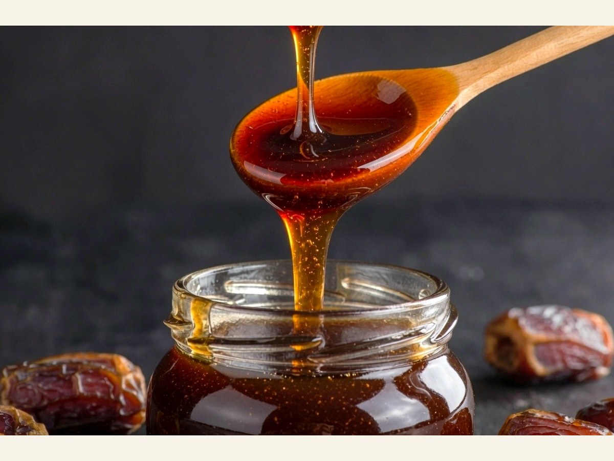 Iranian date syrup poured into a glass jar